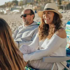 Rodzice rozmawiają z córką na plaży. Ojciec w okularach przeciwsłonecznych, matka w kapeluszu. Czas na szczere rozmowy, jak rozmawiać z synem o dziewczynie.