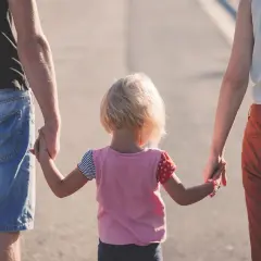 Rodzina idzie razem. Dziecko trzyma za ręce kobietę i mężczyznę, tworząc piękny związek z kobietą z dzieckiem.